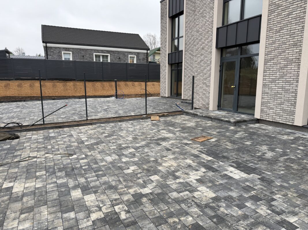 Trinkelių įrengimas kieme prie modernaus gyvenamojo namo Vilniuje