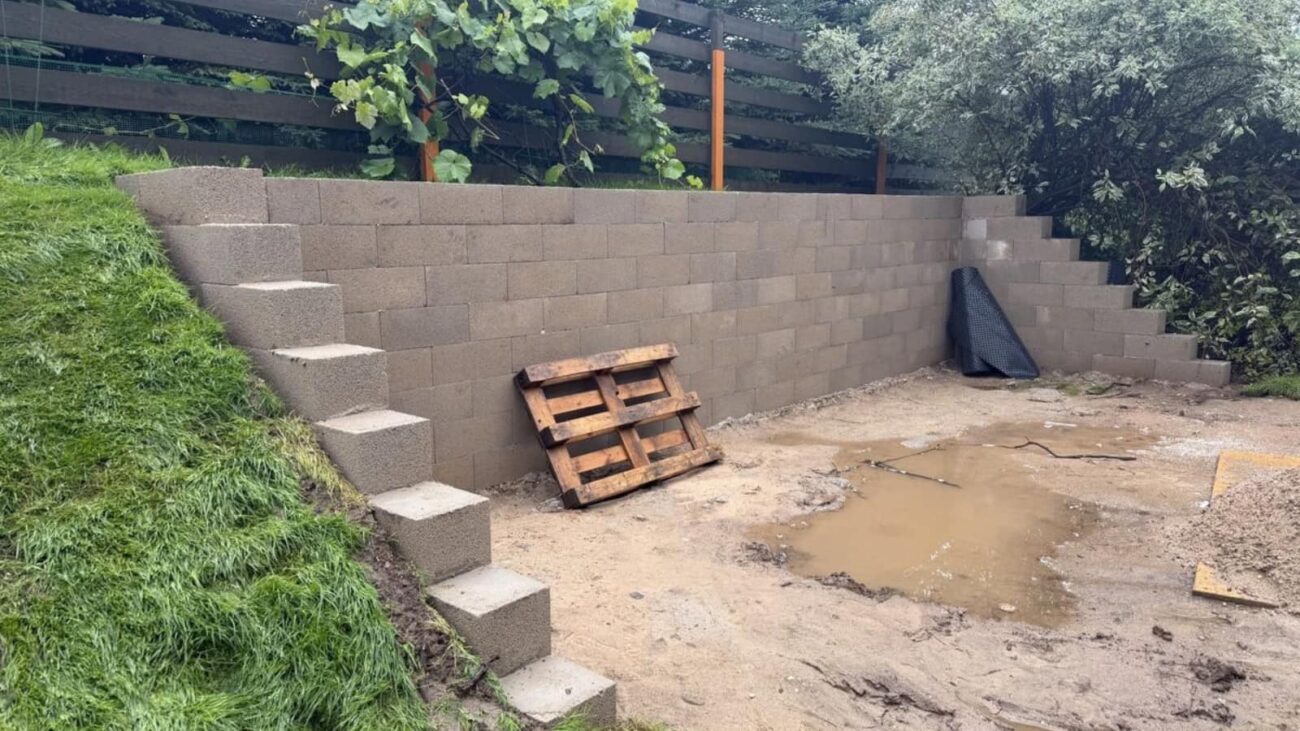 Baigta atraminė sienelė iš betoninių blokelių su laipteliuotu perėjimu į šlaitą